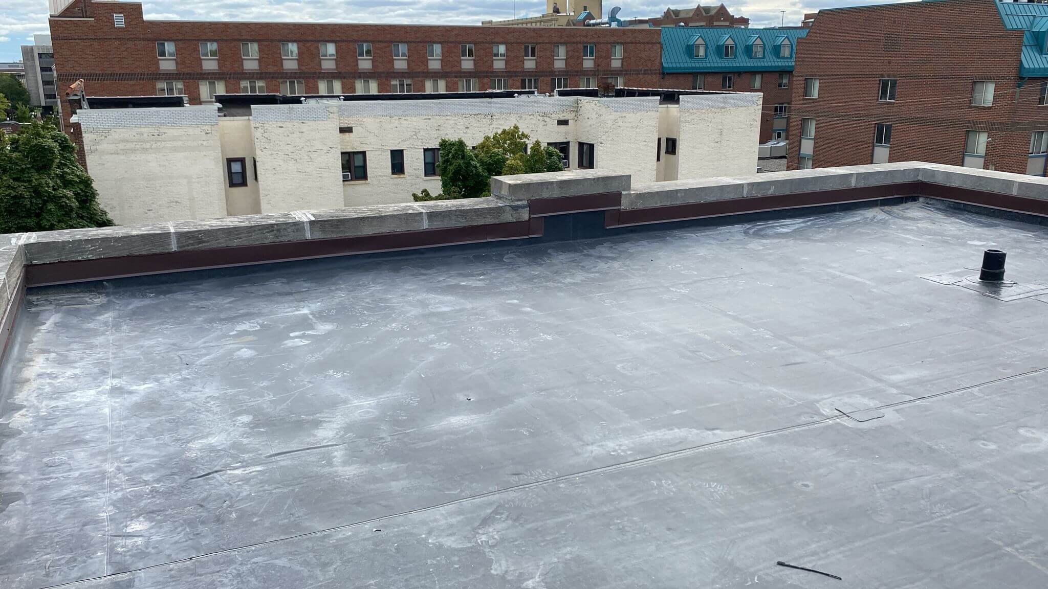 top of a commercial roof with commercial buildings behind it