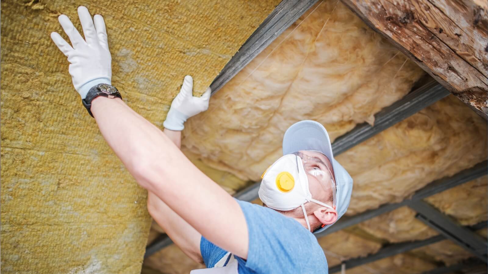 man adding insulation to a home