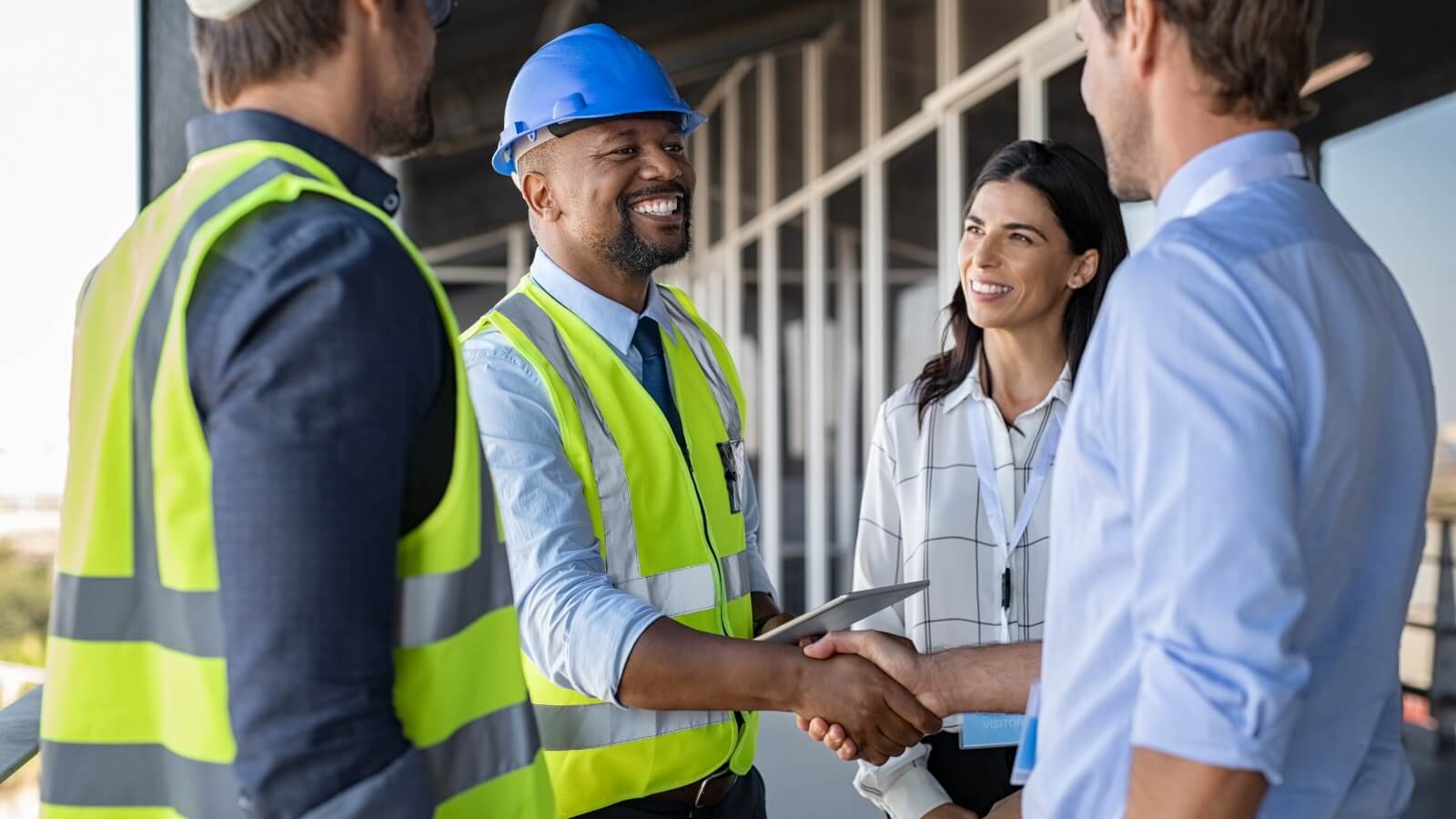 4 people in a group with 2 people shaking hands