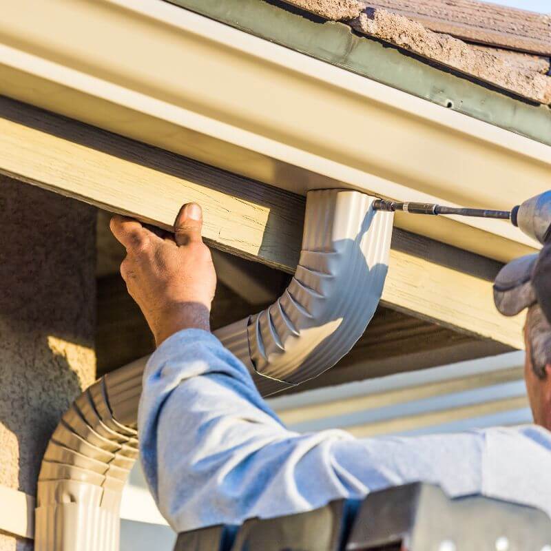 gutter installation man drilling into gutter gutter installation man drilling into gutter