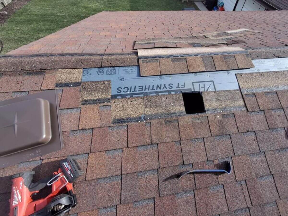 closeup of roof damage with tools around hole