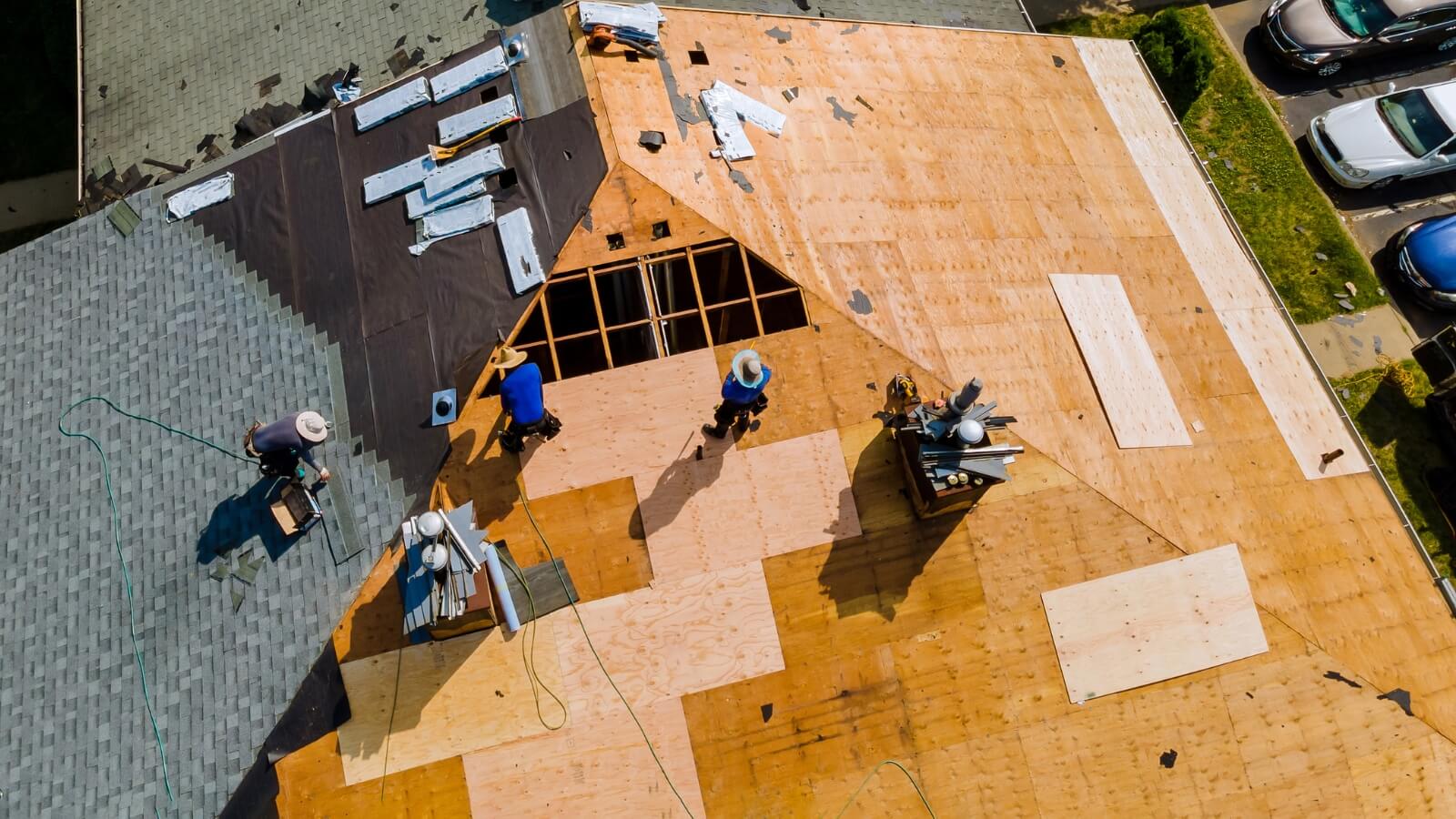 workers on top of a roof being re-decked